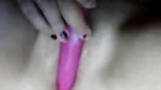 Bored girl plays with a pink dildo